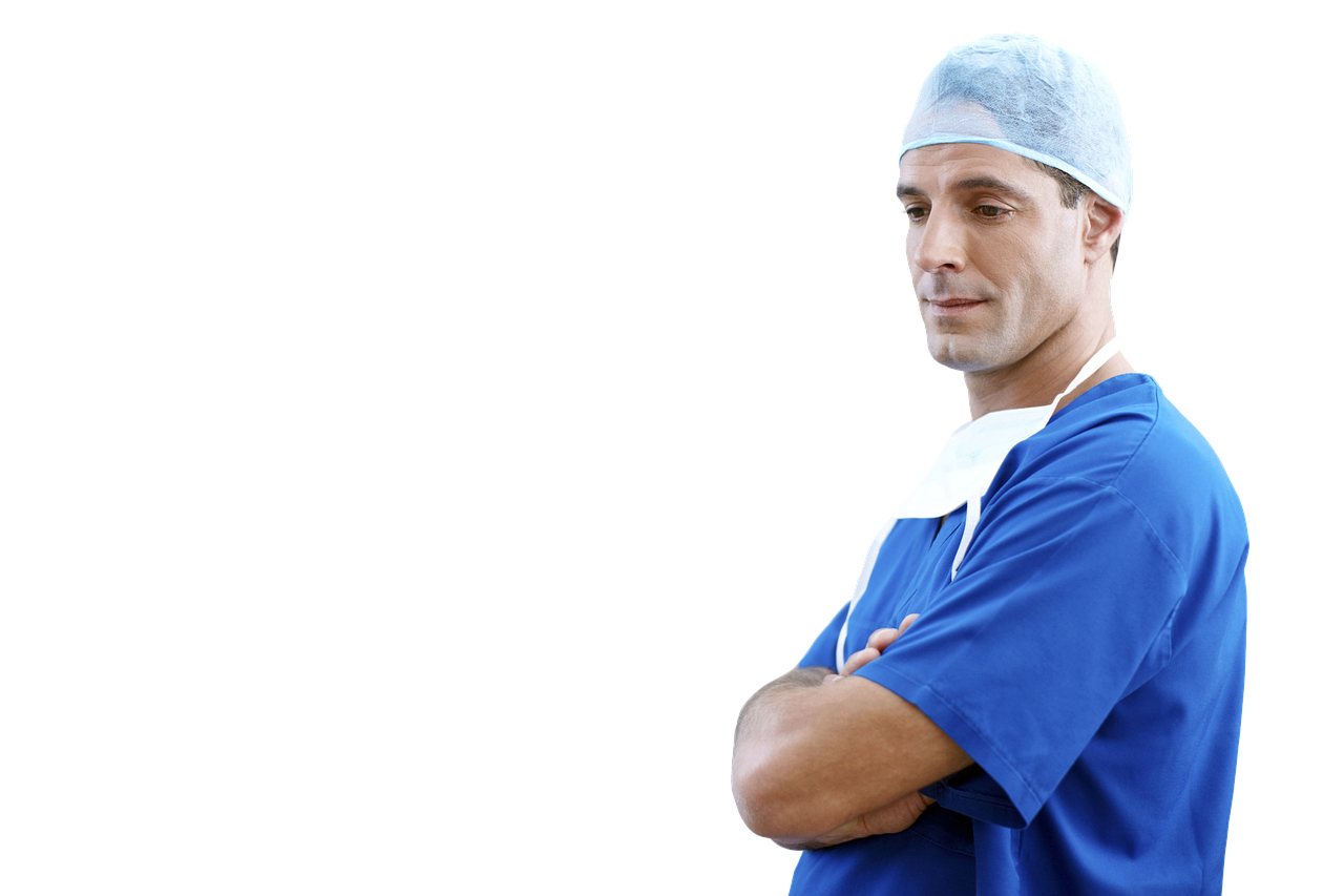 Lekarz stomatolog w stroju lekarskim z założonymi rękami na tle białej ściany